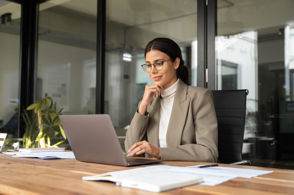 Focused professional financial it specialist latin hispanic business lady working concentrated on laptop pc sitting in office