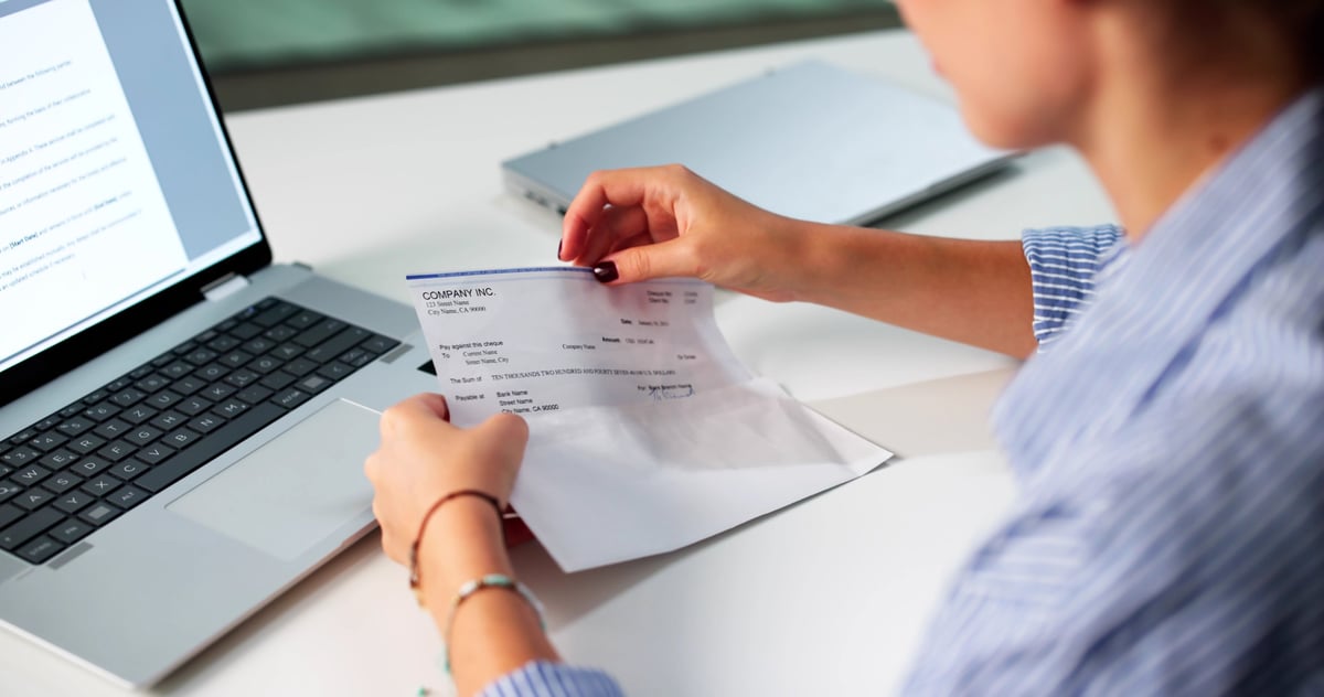 Woman In Office Managing Payroll Compensation Check Envelope With Care